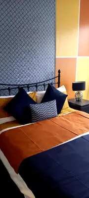 a bed with an orange and blue blanket and pillows at Shananagens Guesthouse in Blackpool