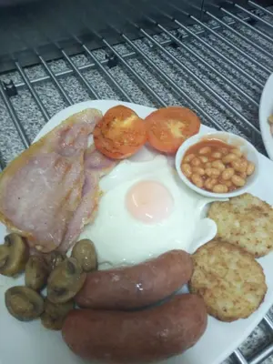 a plate of breakfast food with eggs sausage and beans at Shananagens Guesthouse in Blackpool