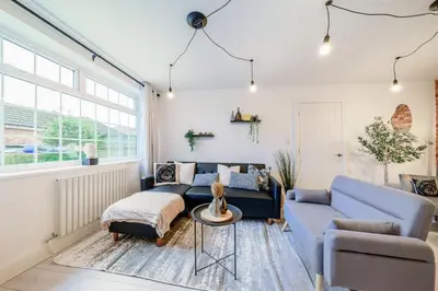 a living room with a blue couch and a table at Large 6-Bed house, Free Parking & Motorway Access in Ashton in Makerfield