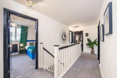 a hallway with a staircase leading to a bedroom at Large 6-Bed house, Free Parking & Motorway Access in Ashton in Makerfield