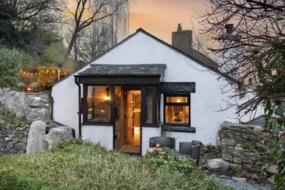 a small white house with a wooden door at Mead Cottage a Tranquil Retreat in the Heart of the Lake District - Ridgestone in Lindale