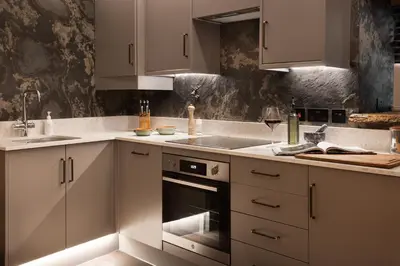 a kitchen with white cabinets and a sink and an oven at Mead Cottage a Tranquil Retreat in the Heart of the Lake District - Ridgestone in Lindale