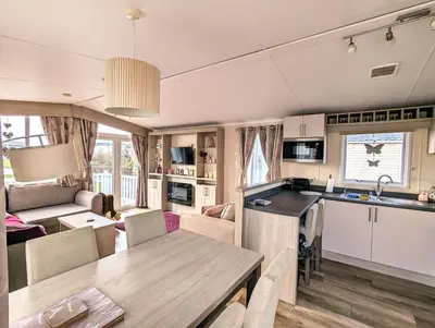 a kitchen and living room with a table and a kitchen and a living room at Jenny and Jamie's holiday home on the edge in Morecambe