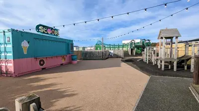 a park with a playground with a roller coaster at Jenny and Jamie's holiday home on the edge in Morecambe