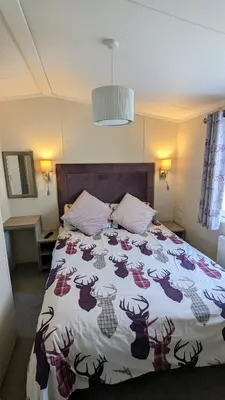 a bedroom with a bed with a deer comforter at Jenny and Jamie's holiday home on the edge in Morecambe