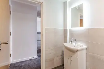 a white bathroom with a sink and a mirror at 1-Bed apartment with Sofa Bed right by Liverpool ONE & Concert Square in Liverpool