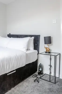 a bedroom with a bed and a table with a lamp at 1-Bed apartment with Sofa Bed right by Liverpool ONE & Concert Square in Liverpool