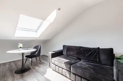 a living room with a black couch and a table at 1-Bed apartment with Sofa Bed right by Liverpool ONE & Concert Square in Liverpool