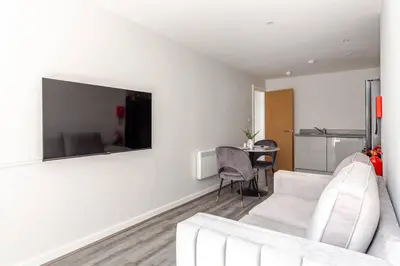 a living room with a white couch and a table at 1-Bed Apartment With Sofa Bed in City Centre, Steps from Bold Street and Nightlife in Liverpool