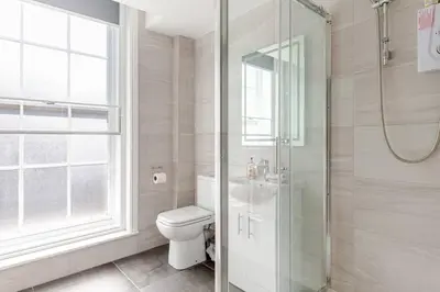 a bathroom with a toilet and a glass shower at 1-Bed Apartment With Sofa Bed in City Centre, Steps from Bold Street and Nightlife in Liverpool