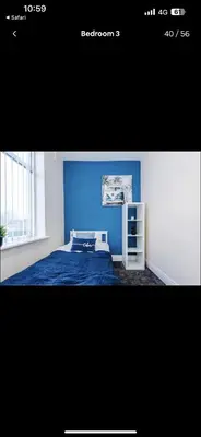 a bedroom with a blue wall and a bed at Cherry Loft in Liverpool