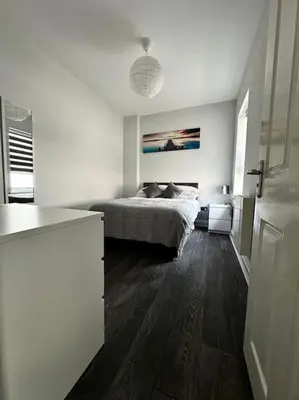 a bedroom with a bed in a white room at JMC's Place in Blackpool