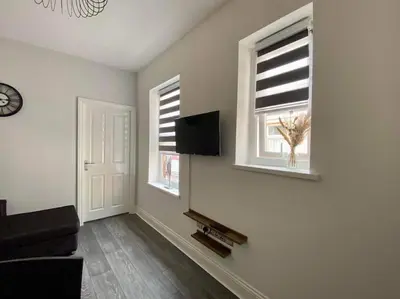 a living room with a couch and two windows at JMC's Place in Blackpool