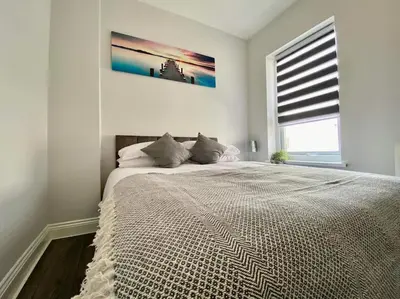 a bedroom with a large bed with a large window at JMC's Place in Blackpool