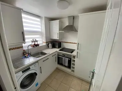 a kitchen with a washing machine and a sink at JMC's Place in Blackpool