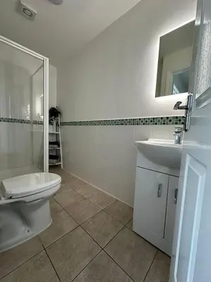 a bathroom with a sink and a toilet and a mirror at JMC's Place in Blackpool