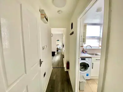 a hallway leading to a kitchen with a washing machine at JMC's Place in Blackpool