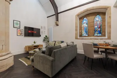 a living room with a couch and a table and a stained glass window at The Spire! Historic Features Rare 1800s Church in Waterloo