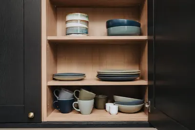 a cupboard with plates and bowls and bowls at The Spire! Historic Features Rare 1800s Church in Waterloo