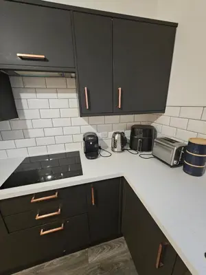 a kitchen with black cabinets and a counter top at Market Quarter, town centre, free parking and wifi in Southport