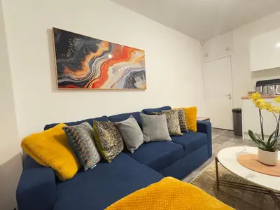 a blue couch with pillows on it in a living room at City Link Apartments Perfect Stay for Concert Goers, Football Fans and Contractors, Closer to Liverpool City Centre, Everton, Liverpool Grounds in Liverpool