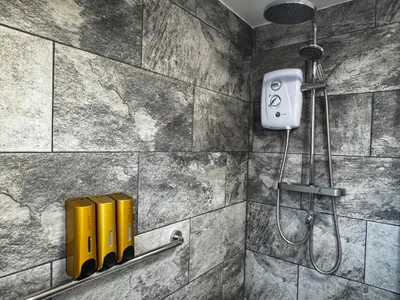 a bathroom with a shower with yellow soap dispensers at City Link Apartments Perfect Stay for Concert Goers, Football Fans and Contractors, Closer to Liverpool City Centre, Everton, Liverpool Grounds in Liverpool