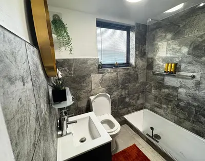 a bathroom with a sink and a toilet and a tub at City Link Apartments Perfect Stay for Concert Goers, Football Fans and Contractors, Closer to Liverpool City Centre, Everton, Liverpool Grounds in Liverpool