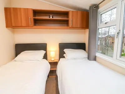 two beds in a small room with two windows at 6 Sherwood in Carnforth