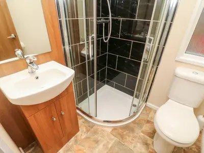 a bathroom with a shower and a toilet and a sink at 6 Sherwood in Carnforth