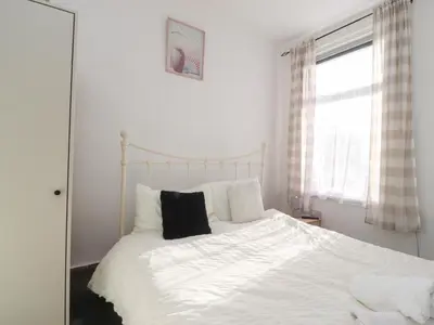 a bedroom with a white bed with a black pillow at 21 Eaves Street in Blackpool