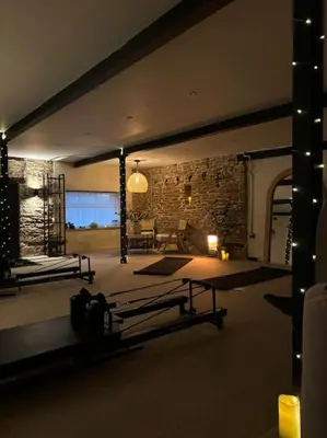 a living room with a table and a stone wall at The Retreat in Eccleston