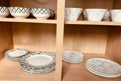 a shelf with white plates and bowls on it at The Retreat in Eccleston