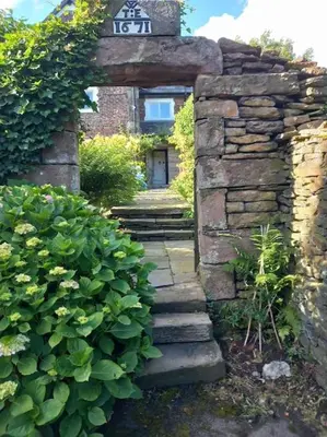 a stone pathway leading to a house with a sign on it at The Retreat in Eccleston