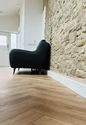 a black chair sitting next to a stone wall at The Retreat in Eccleston