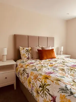 a bedroom with a bed with a floral bedspread at The Retreat in Eccleston