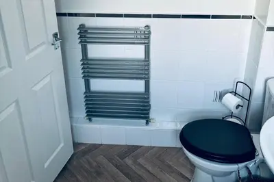 a bathroom with a toilet with a black seat at House - Sleeps 6 Hot-tub & Free Parking in Skelmersdale