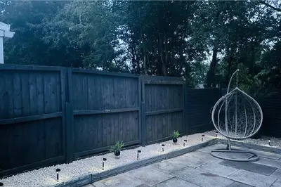 a wooden fence with a fan in a yard at House - Sleeps 6 Hot-tub & Free Parking in Skelmersdale