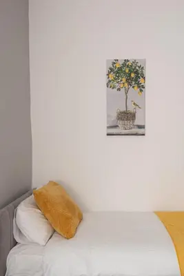 a pillow on a bed with a picture on the wall at Modern 3 bed, sleeps 8 in Saint Helens