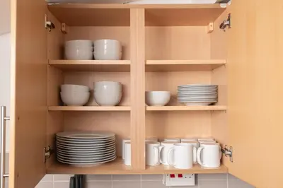 a cupboard with plates and dishes in it at Modern 3 bed, sleeps 8 in Saint Helens