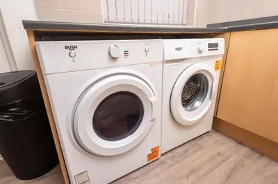 a washing machine and a dryer in a room at Modern 3 bed, sleeps 8 in Saint Helens