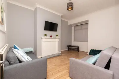 a living room with a couch and a tv at Modern 3 bed, sleeps 8 in Saint Helens