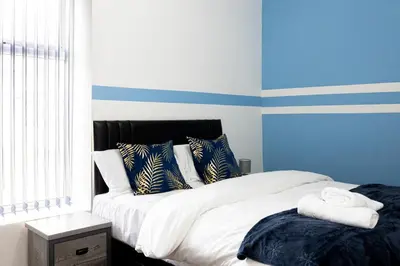 a bedroom with a bed with blue and white stripes at Family Stay on Barnes Street in Clayton le Moors
