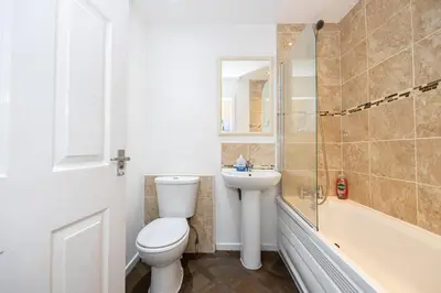 a bathroom with a toilet and a sink and a tub at Family Stay on Barnes Street in Clayton le Moors