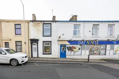 a white car parked in front of a building at Family Stay on Barnes Street in Clayton le Moors