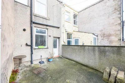 a patio with a table in front of a building at Family Stay on Barnes Street in Clayton le Moors