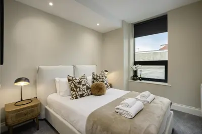 a bedroom with a large white bed with a window at The Shoreline Collection by STAMP in Blackpool