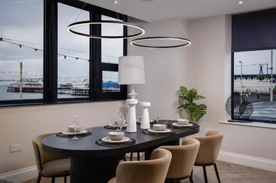 a dining room with a black table and chairs at The Shoreline Collection by STAMP in Blackpool