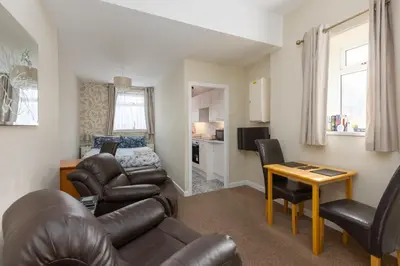 a living room with a couch and a table at Beachcliffe Holiday Apartments in Blackpool