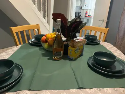 a table with a green table cloth and a bottle of wine at true and fruitful vine by Everton and Liverpool footy club in Liverpool