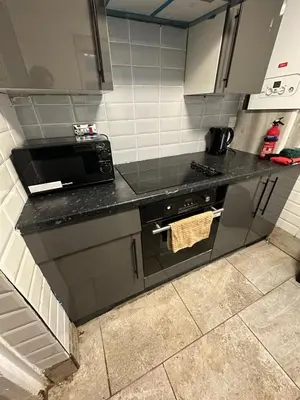 a kitchen with a stove and a microwave at true and fruitful vine by Everton and Liverpool footy club in Liverpool